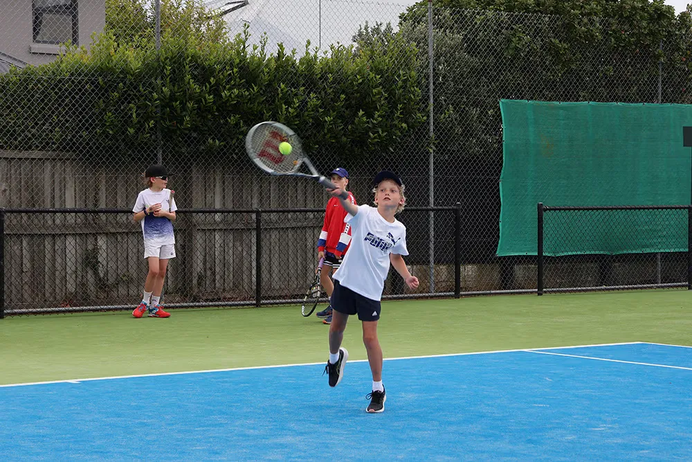 A young player hits a great forehand while practicing on court at the Waimairi Tennis Club